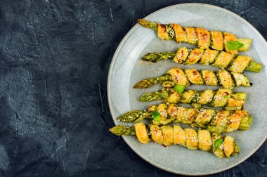 Hamur içinde pesto sosuyla pişirilmiş sağlıklı yeşil kuşkonmaz. Metin için boşluk.