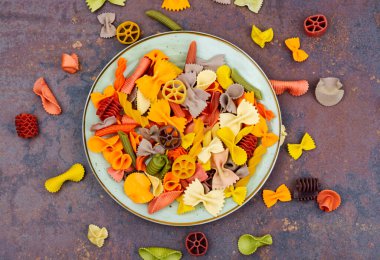 Çocuklar için pişmemiş çok renkli farfalle makarna veya makarna.