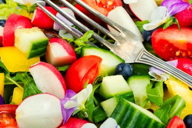 Parlak sebze salatası, yenilebilir çiçekler, menekşeler. Temiz yemek. Kapat..