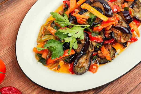 ナスと野菜のソテー 古いキッチンテーブルの上のベジタリアン料理 — ストック写真