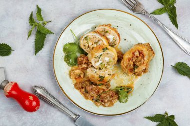 Dilimlenmiş istiridye, pirinçle doldurulmuş mürekkep balığı ve açık gri arka planda ısırgan otu. Kore yemeği..