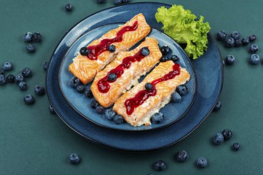 Seramik tabakta yabanmersini soslu fırında somon balığı filetosu. Deniz ürünleri..