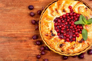 Mevsimlik turta, kırmızı frenk üzümü, bektaşi üzümü ve ahşap bir masada taze böğürtlen. Boşluğu kopyala.