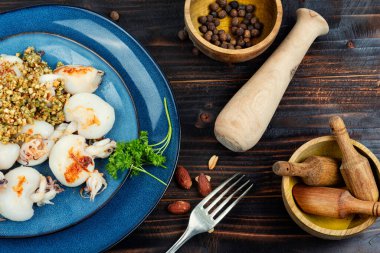 Pişmiş taze mürekkep balığı veya ahşap masada fındıklı kalamar..