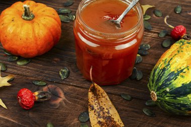 Balkabağı reçeli ya da cam kavanozda püre ve eski ahşap masada taze balkabağı. Sonbahar sakin bir hayat.