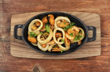 Izgara midye, kalamar, karides ve çubuk. Çeşitli deniz ürünleri.