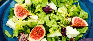 Yeşillik vitamin salatası, olgun incir ve diyet peynir. Gıda arkaplanı