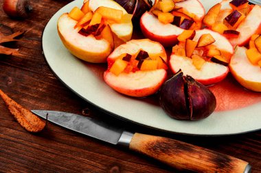 Fırınlanmış sonbahar yarıları elmalar ve incirler. Kırsal ahşap arka planda ev yapımı vejetaryen tatlısı.