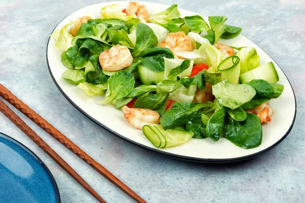 Plate with appetizing shrimps salad with green lettuce. Salad of shrimp or prawns. Healthy eating.