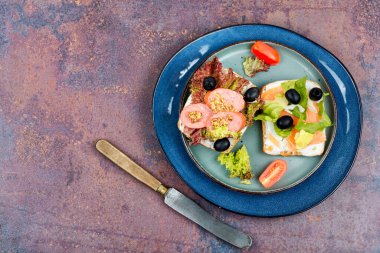 Alabalık ve sosisli sandviç aç. Krem peynirli balık, salam, zeytin ve sebzeli ekmek. Kahvaltı, kafe menüsü. Üst Manzara. Boşluğu kopyala.