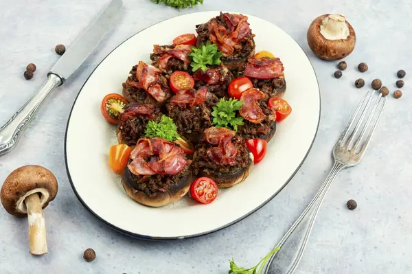 Roasted champignon mushrooms stuffed with vegetables, minced meat and bacon.