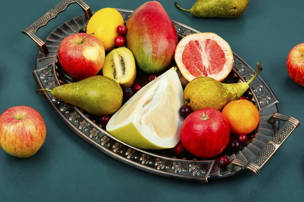Apples, pears, mangoes and citrus fruits on a stylish tray.