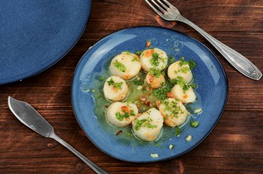 Kızarmış lezzetli deniz tarakları, yeşil tabakta.