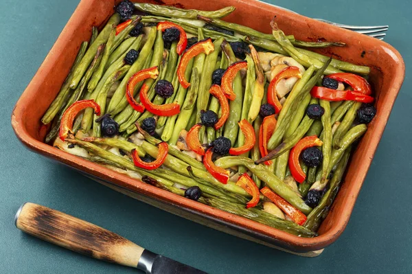 Homemade baked vegetable pie with green or bush beans and peppers in baking dish.