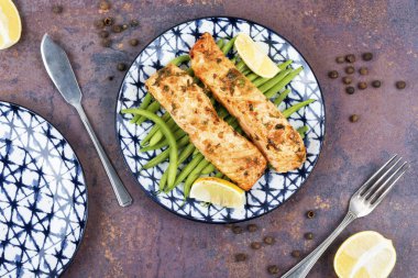 Tabağında yeşil fasulye kabukları olan kızarmış somon balığı. Paleo, keto diyeti.