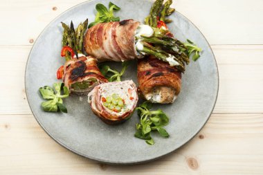 Ahşap masada yeşil kuşkonmazla doldurulmuş rosto köftesi..