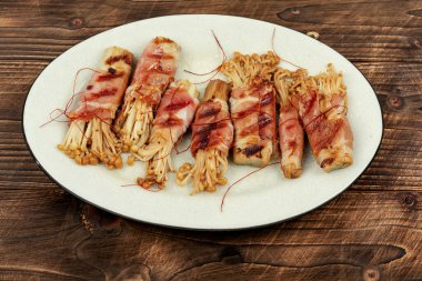 Enoki mantarı aperatifi ahşap masada domuz pastırması ile kızartılmış. Asya mutfağı