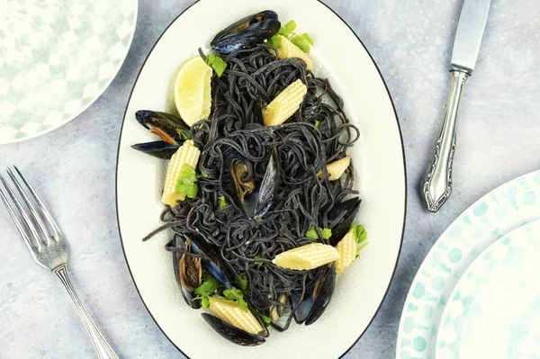Vegan black bean pasta with boiled mussels. Spaghetti with seafood. Top view.