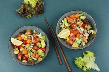 Taze sebzeli lezzetli salata ve tabakta deniz ürünleri. Üst görünüm.