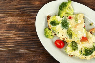 Brokoli, karides ve kiraz domatesli omlet. Köy ahşap dokusunda. Metin için boşluk.