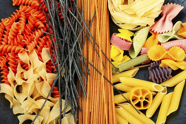 Various kinds of uncooked pasta, noodles and spaghetti. Macro.