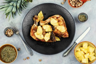 Kızarmış tavuk budu ve ananas dilimleri. Fırında tavuk eti. Düz yatıyordu.