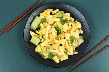 Lezzetli yaz salatası ananas, salatalık, salatalık, fındık salatası ve çubuk. Düz yatıyordu.