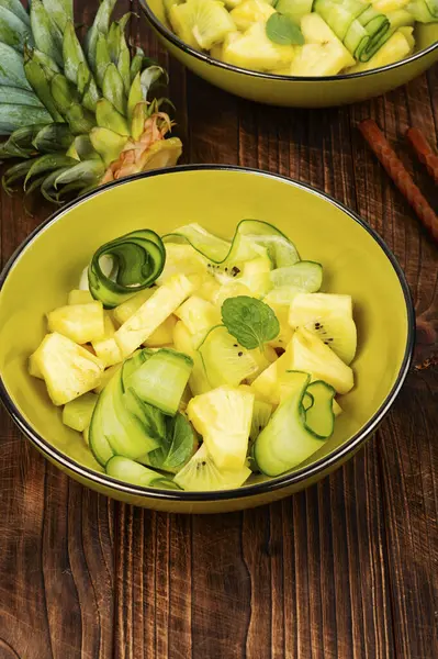Eski ahşap masa üzerinde taze ananas ve salatalık salatası. Sağlıklı, dengeli, diyet yemekleri..