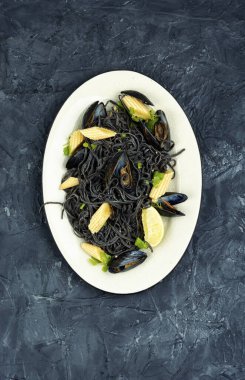 Midyeli vejetaryen fasulyeli makarna. Beton mutfak masasında deniz mahsullü spagetti..