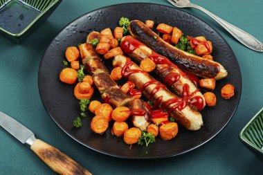 Kızarmış hindi eti sosisi, domates ketçaplı ve kızarmış havuçlu. Karışık kızarmış sosisler..