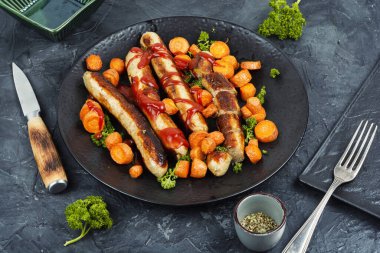 Fırında ya da ızgara hindi sosisi ve tavada kızarmış havuç. Almanca barbekü menüsü.