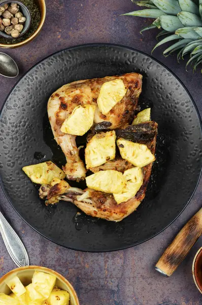 Ananas parçalarıyla servis edilen kızarmış tavuk budu. Kızarmış tavuk eti. Üst görünüm.