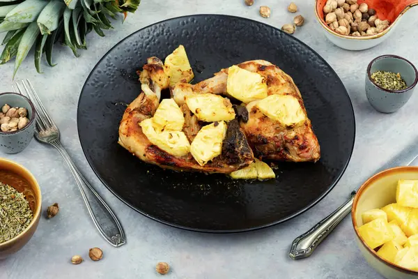 Ananas dilimleriyle kızartılmış tavuk budu. Tabakta ızgara tavuk eti.