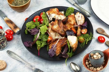 Dilimlenmiş ızgara tavuk ve bir tabak kirazlı domates..