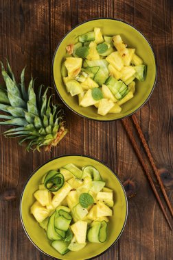 Ananas, salatalık ve fındıklı iştah açıcı salata. Kırsal ahşap masada sağlıklı beslenme. Düz yatıyordu.