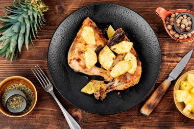 Ananas parçalarıyla kızartılmış tavuk bacağı. Kızarmış tavuk, ızgara tavuk budu eski ahşap masada..