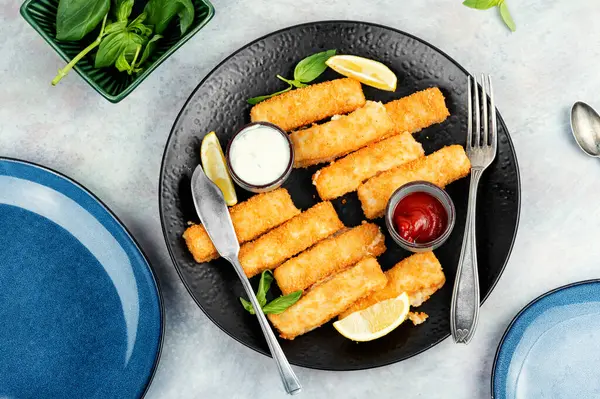 Delicious fish fingers or nuggets, crispy fish steak on the plate.