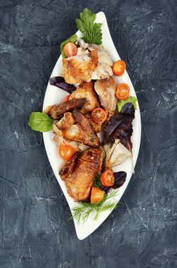 Lezzetli kızarmış tavuklar tabakta yeşil.