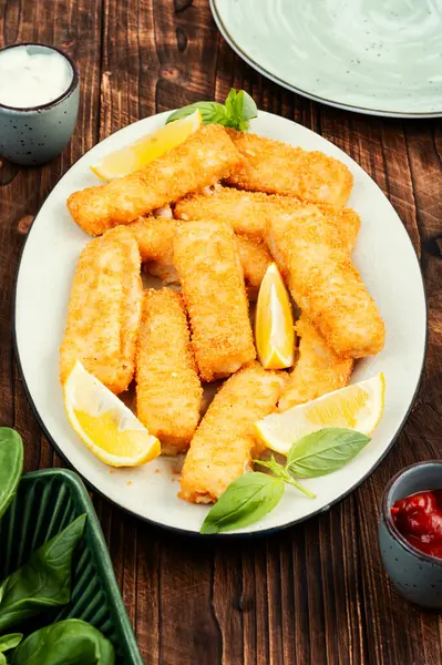 Fish fingers or nuggets, crispy fish steak on the plate. Fish sticks.