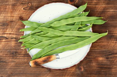 Çiğ fasulye, kırsal ahşap bir masada organik yeşil fasulye. Düz yatıyordu