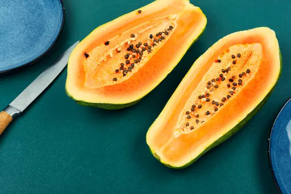 用刀把新鲜多汁木瓜切碎在桌上 成熟的木瓜果切成两半 — 图库照片