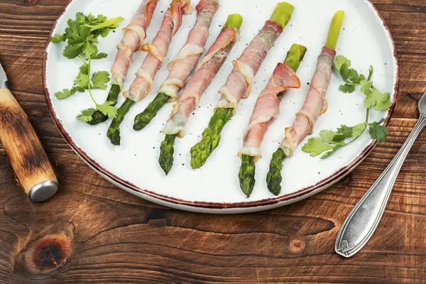 美味的芦笋与培根包裹在乡村木桌上 健康的食物 健康的饮食 图库图片