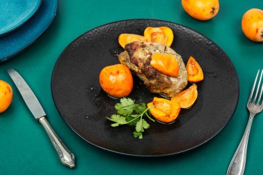 Kızarmış ızgara fileto et ve sulu lokuat meyveleri. Lezzetli et parçası olgun meyveyle kavrulmuş.