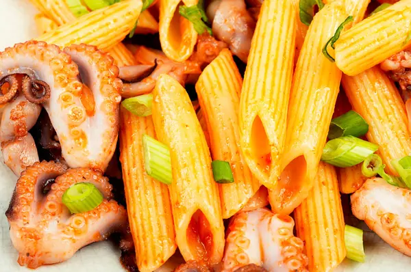 Appetizing macaroni or pasta boiled with octopus. Pasta with seafood. Close up.