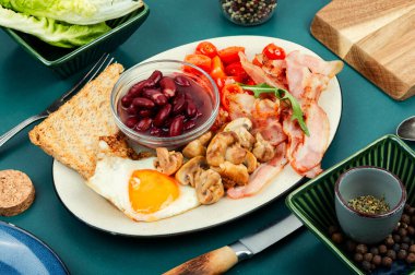 İngiliz kahvaltısı: kızarmış yumurta, kızarmış pastırma, sebze, fasulye ve bir tabakta tost..