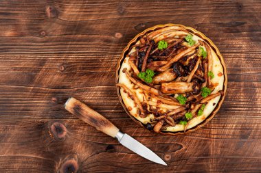 Tahta bir masada mantarlı turta ya da mantarlı galette. Şitake mantarlı tart ya da turta. Metin için boşluk.