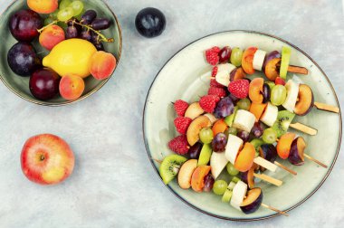 Tahta şişler üzerinde egzotik meyvelerden yapılan iştah açıcı meyve şişleri..