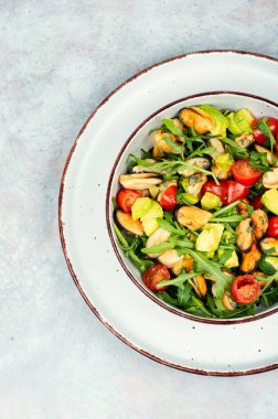 Midyeli salata ve cam tabakta roka. Üst görünüm