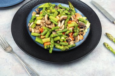 Taze yeşil kuşkonmaz salatası ve kızarmış mantar tabağı..