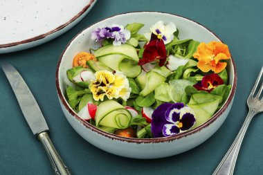 Taze yeşil sebze salatası, yenilebilir çiçekler, tarla menekşeleri, menekşeler. Detoks gıdası